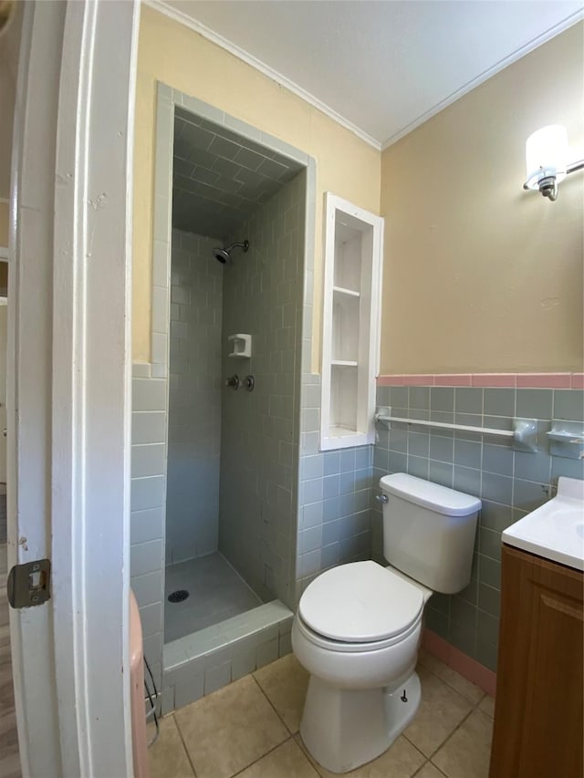 bathroom with tile patterned floors, toilet, tile walls, and a tile shower