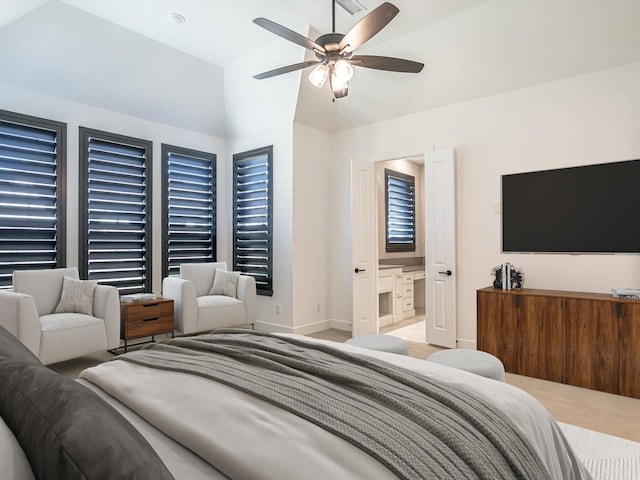 bedroom with light carpet, connected bathroom, vaulted ceiling, and ceiling fan