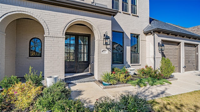 entrance to property with a garage and french doors