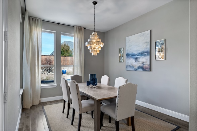 dining room featuring wood-type flooring and an inviting chandelier