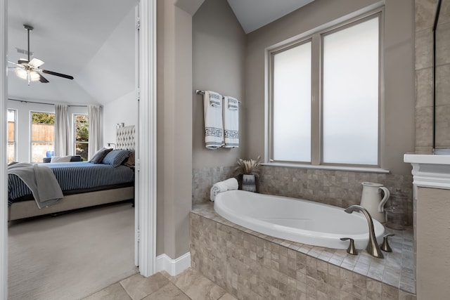 bathroom featuring vaulted ceiling, a relaxing tiled tub, and ceiling fan