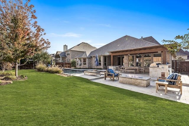 rear view of house with an outdoor fire pit, a yard, an outdoor stone fireplace, and a patio area