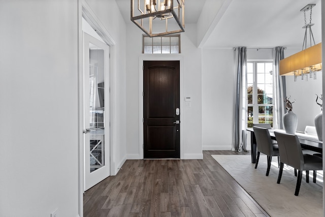 entrance foyer featuring dark wood-type flooring and a notable chandelier