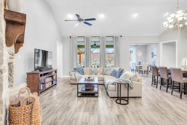 living room featuring ceiling fan with notable chandelier, light hardwood / wood-style flooring, and high vaulted ceiling