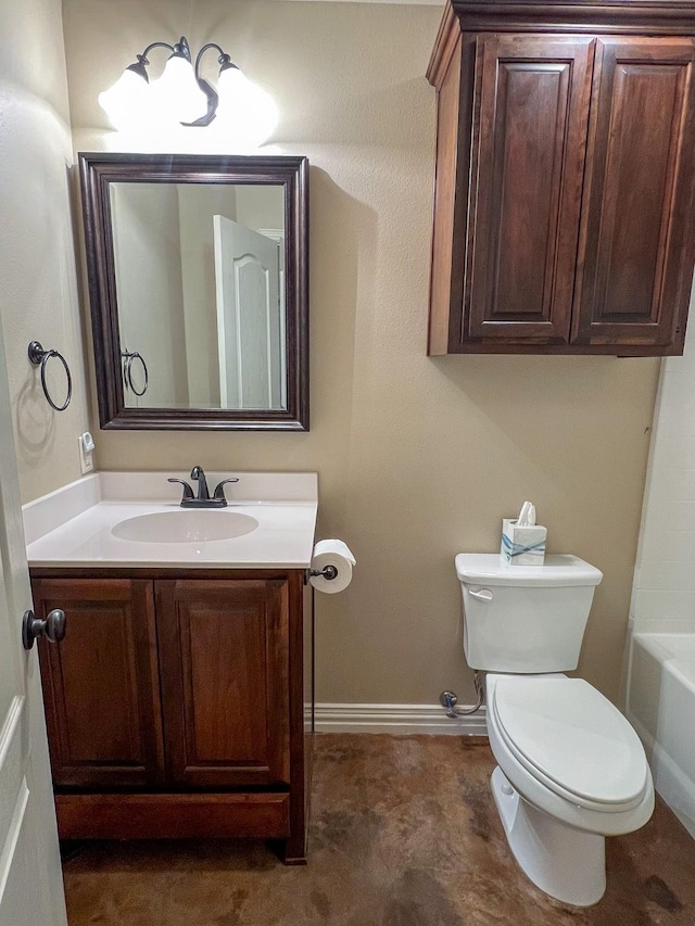 bathroom with a chandelier, vanity, toilet, and a tub