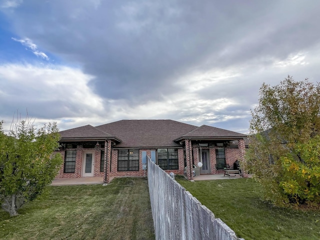 prairie-style home with a front yard and a patio