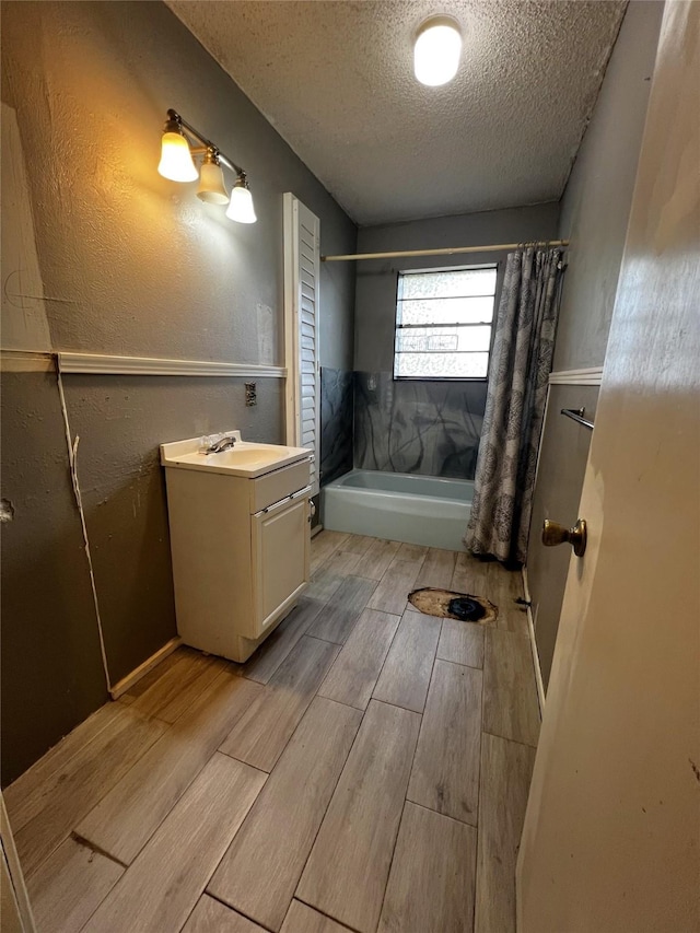 bathroom with vanity, shower / tub combo, a textured ceiling, and hardwood / wood-style flooring