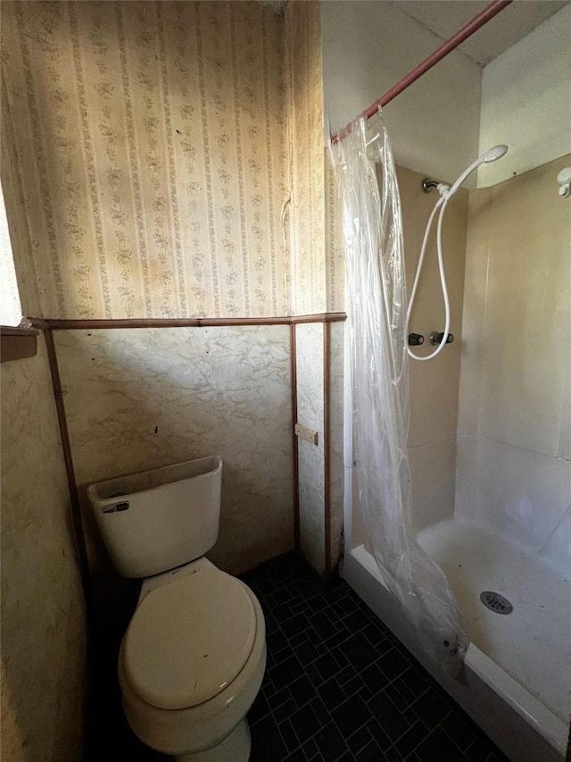 bathroom with tile patterned flooring, toilet, and walk in shower