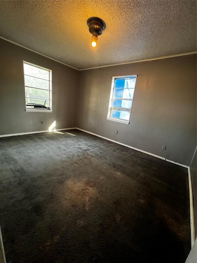 empty room featuring dark carpet, a textured ceiling, and ornamental molding