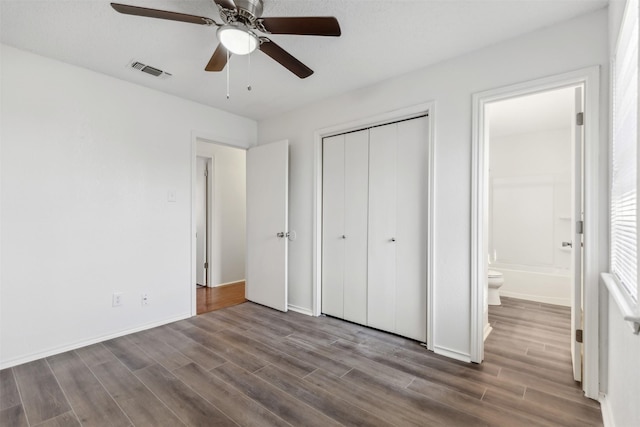 unfurnished bedroom with wood-type flooring, connected bathroom, and ceiling fan