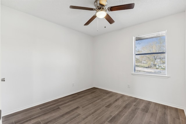 empty room with ceiling fan and dark hardwood / wood-style flooring