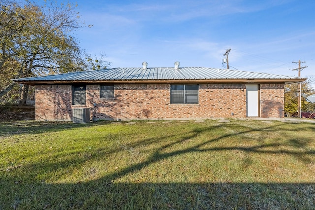 back of property featuring a yard and central AC unit