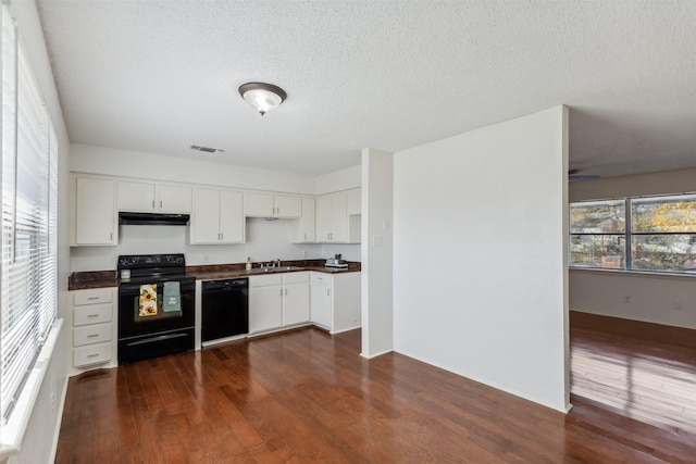 kitchen with a textured ceiling, dark wood-type flooring, sink, black appliances, and white cabinetry