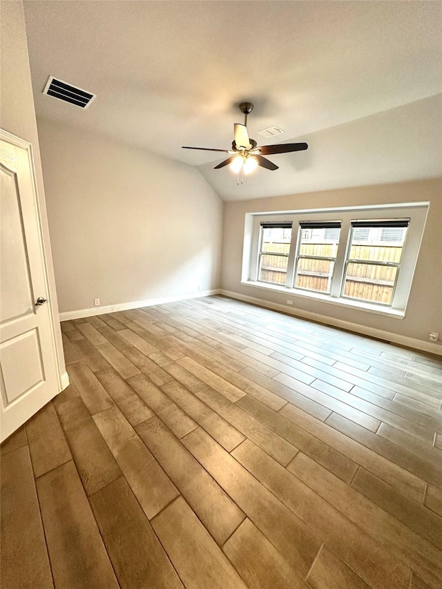 empty room featuring lofted ceiling, hardwood / wood-style flooring, and ceiling fan