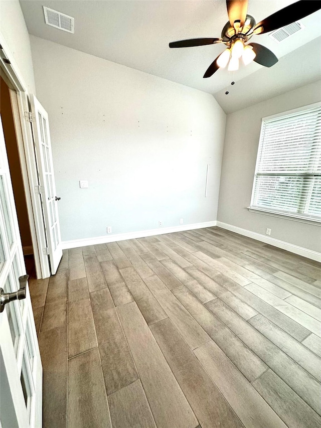 spare room featuring lofted ceiling, light hardwood / wood-style flooring, and ceiling fan