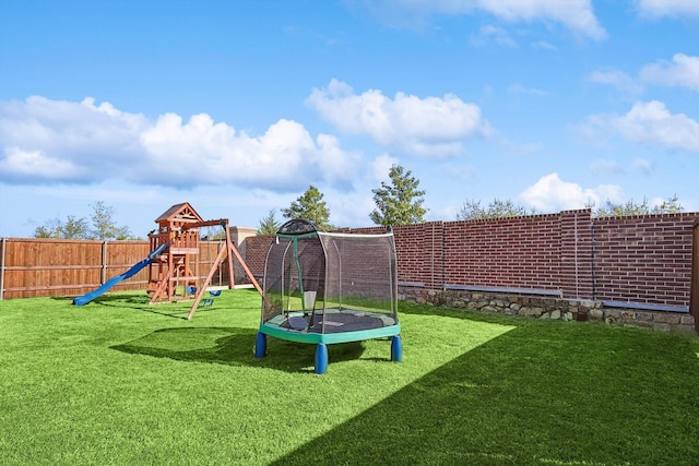 view of play area with a trampoline and a lawn