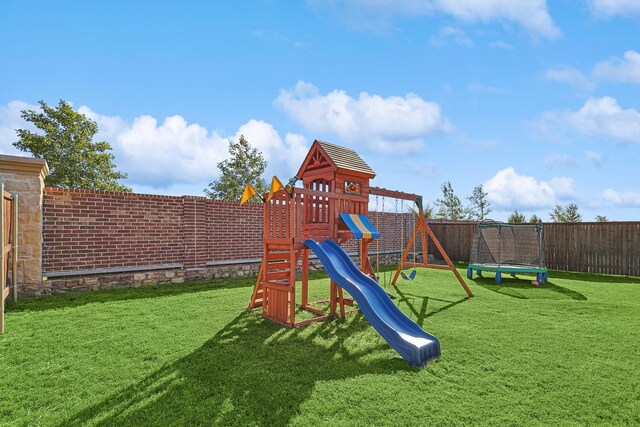 view of play area with a trampoline and a lawn