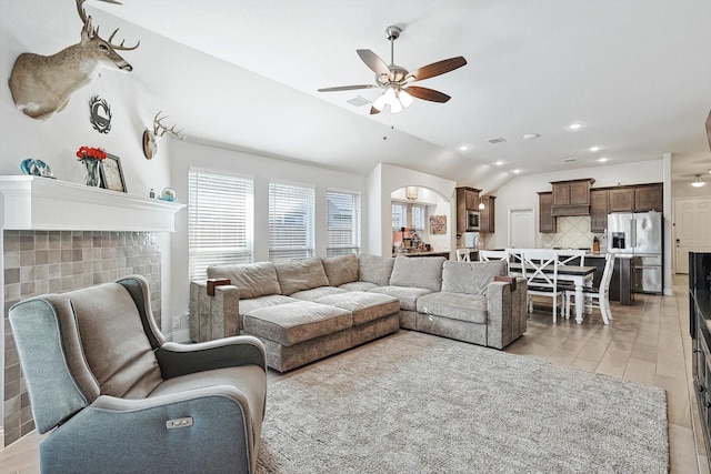 living room featuring ceiling fan, lofted ceiling, and light hardwood / wood-style flooring