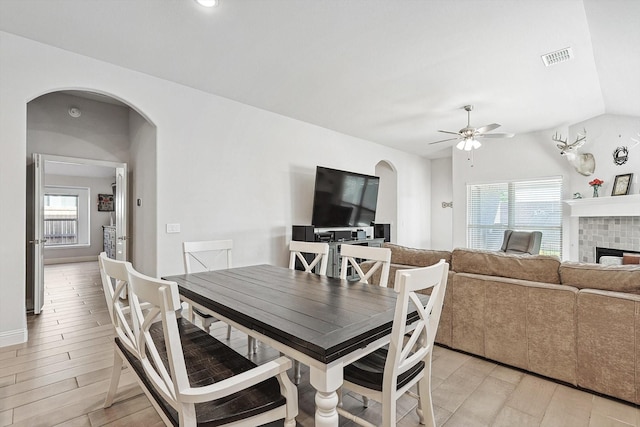 dining room with ceiling fan, plenty of natural light, vaulted ceiling, and light wood-type flooring