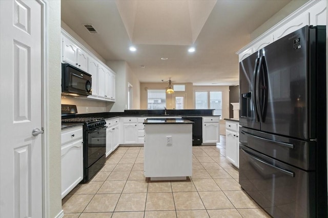 kitchen featuring a center island, black appliances, kitchen peninsula, white cabinetry, and light tile patterned floors