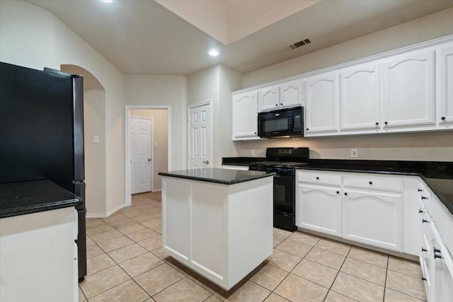 kitchen with light tile patterned floors, white cabinets, black appliances, and a center island