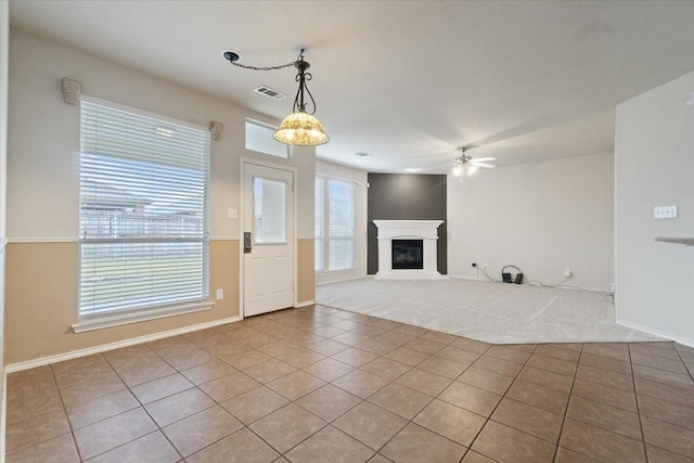 unfurnished living room with ceiling fan and light tile patterned flooring