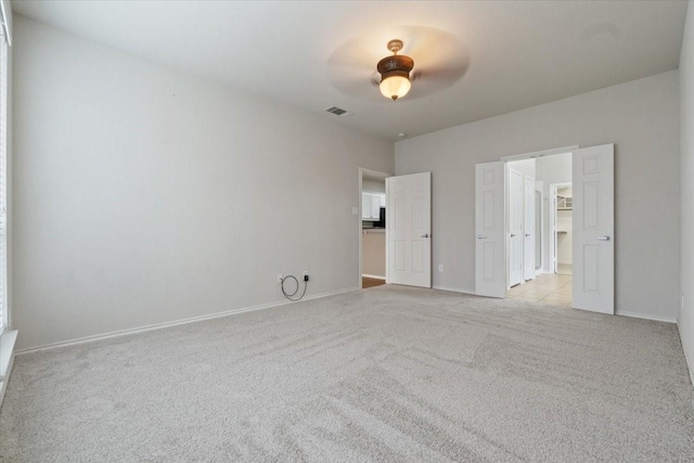 unfurnished bedroom with ceiling fan and light carpet