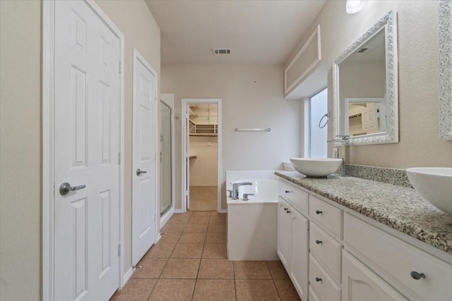 bathroom featuring tile patterned floors, vanity, and shower with separate bathtub