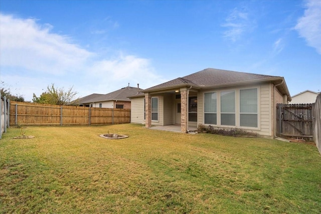 back of property with a yard and a patio