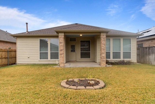 rear view of house featuring a lawn and a patio