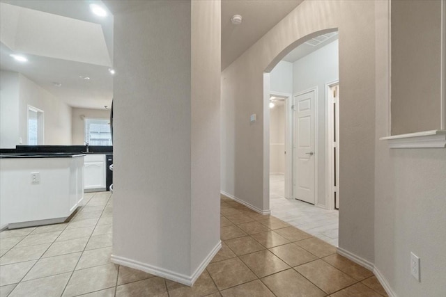 hall with sink and light tile patterned floors