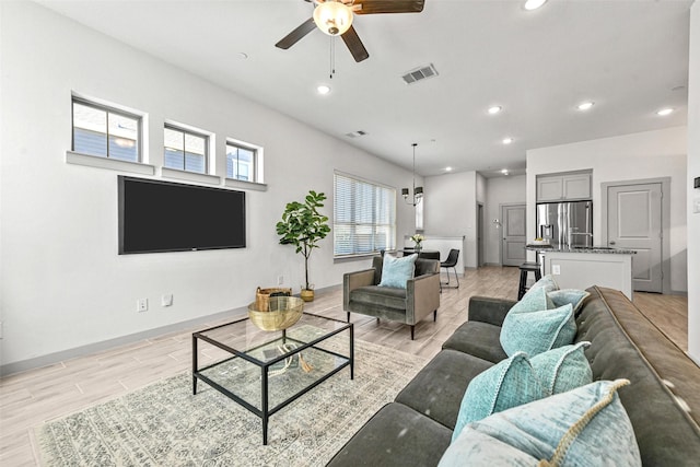 living room featuring ceiling fan and light wood-type flooring