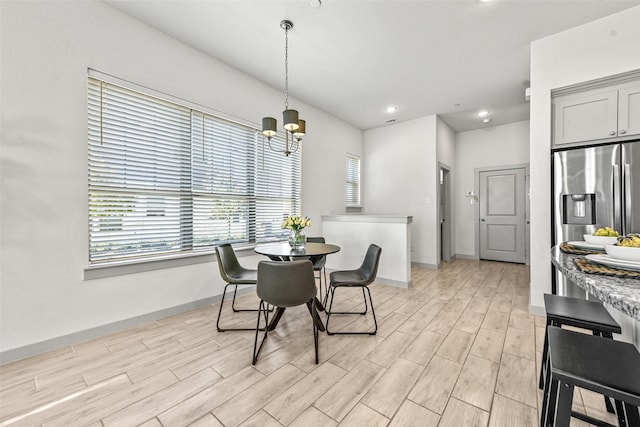 dining space with a notable chandelier and light hardwood / wood-style floors