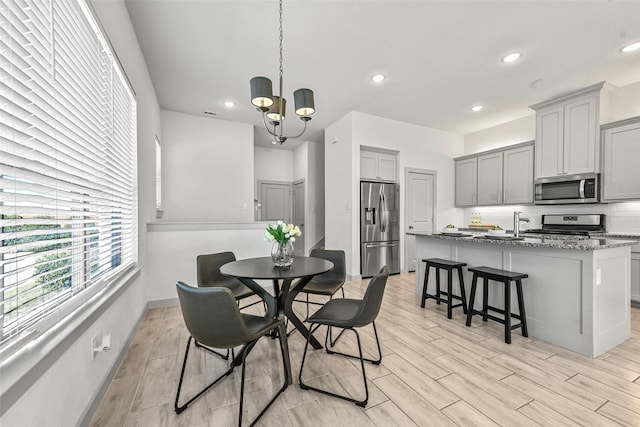 dining area with a notable chandelier and light hardwood / wood-style flooring