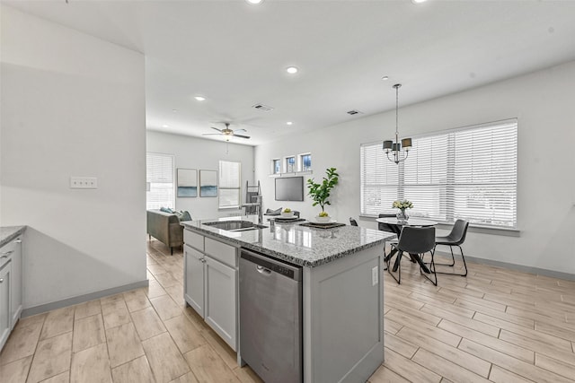 kitchen with a center island with sink, sink, stainless steel dishwasher, ceiling fan, and decorative light fixtures