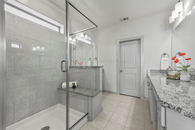 bathroom with vanity, tile patterned floors, and a shower with door