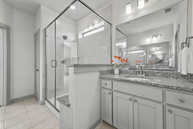 bathroom with tile patterned floors, vanity, and a shower with shower door