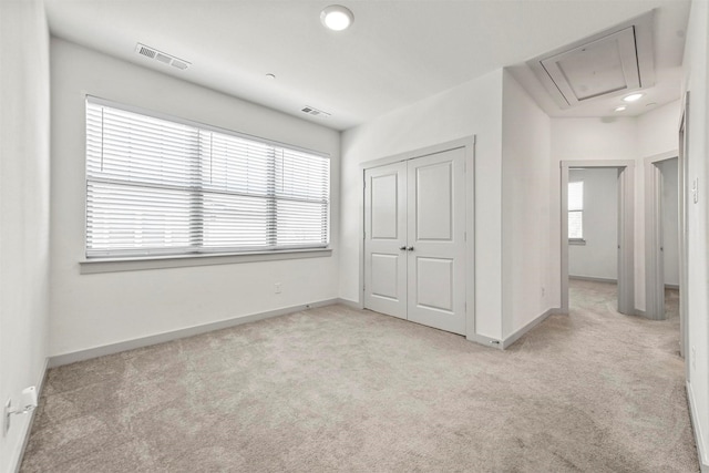 unfurnished bedroom with light carpet and a closet