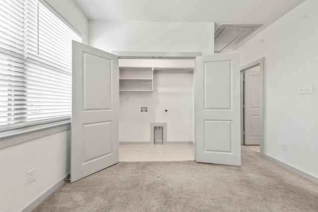 interior space with electric dryer hookup, washer hookup, light carpet, and plenty of natural light