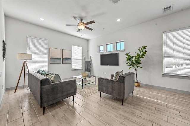 living room with ceiling fan, a healthy amount of sunlight, and light wood-type flooring