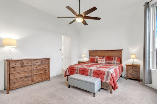 bedroom featuring ceiling fan, light colored carpet, and vaulted ceiling