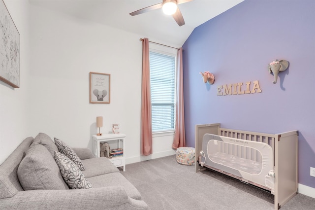 carpeted bedroom with lofted ceiling, a nursery area, and ceiling fan