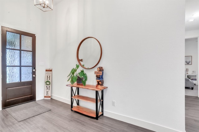 entryway featuring wood-type flooring and an inviting chandelier