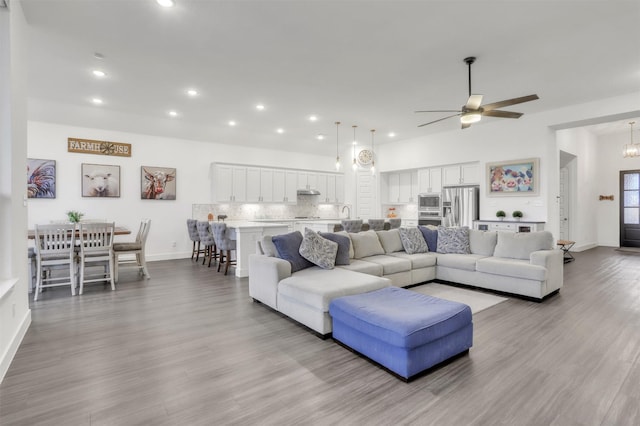 living room featuring light wood-type flooring and ceiling fan