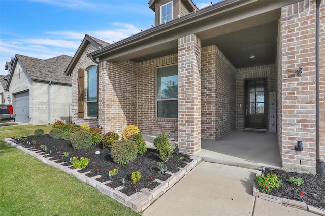 view of exterior entry featuring covered porch and a garage