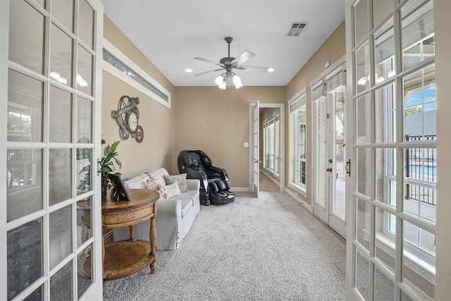 living area with french doors, carpet floors, and ceiling fan