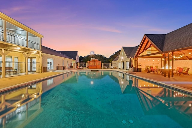 pool at dusk featuring a patio area