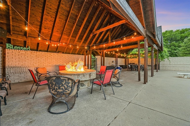 patio terrace at dusk featuring a gazebo and an outdoor fire pit