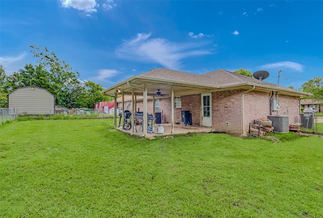 back of house with central AC unit, ceiling fan, a patio area, and a yard