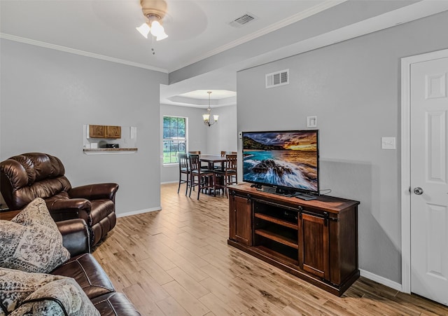 living room with crown molding, light hardwood / wood-style floors, and ceiling fan with notable chandelier